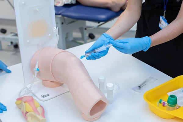 Close up of trainee doctor performing a simulated knee aspiration